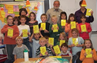 Marcellus Grange presents dictionaries to elementary students